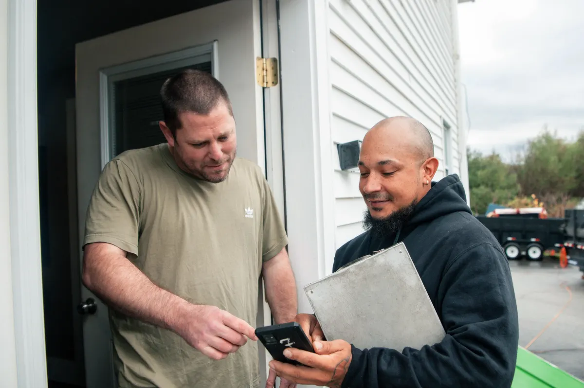 A crew member confirming the price with a customer at the door
