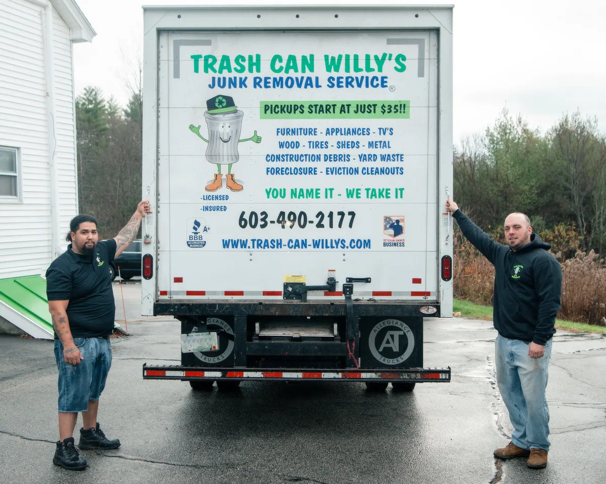 Two crew members at the back of a Trash Can Willy's box truck