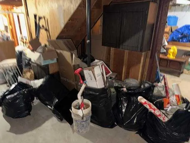 Bagged basement clutter staged under the stairs