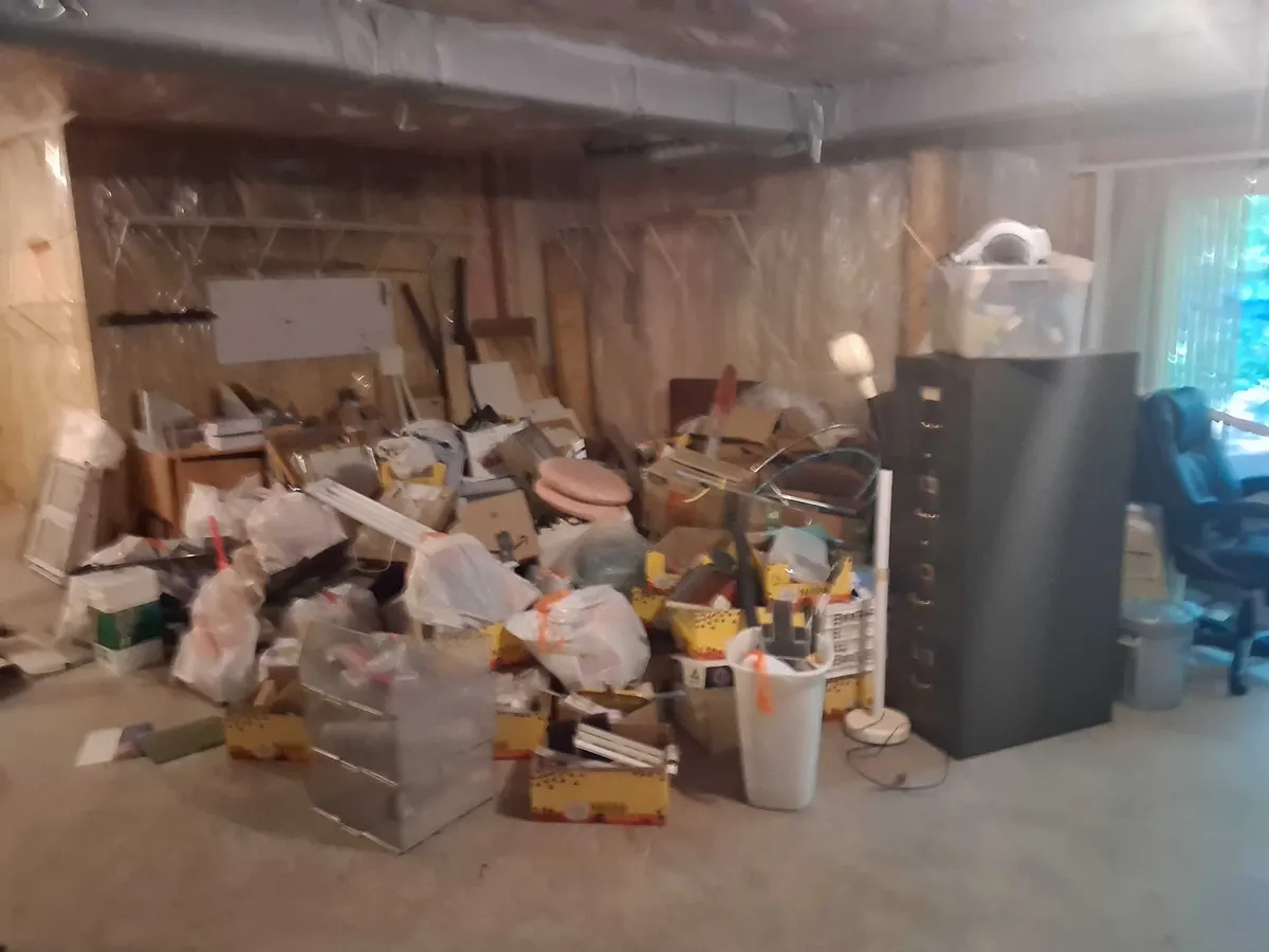 A basement filled wall to wall with boxes, bins and bags