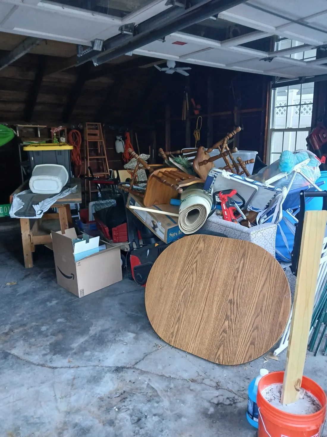 A garage packed with furniture, boxes and a rolled rug before a cleanout