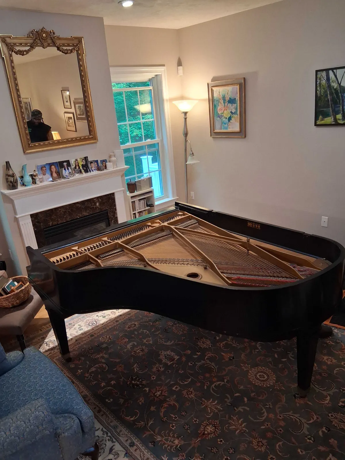 A grand piano in a living room before the crew removes it