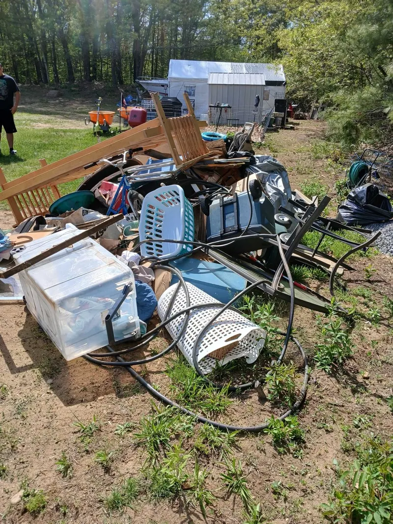 A backyard pile of junk before a Trash Can Willy's pickup