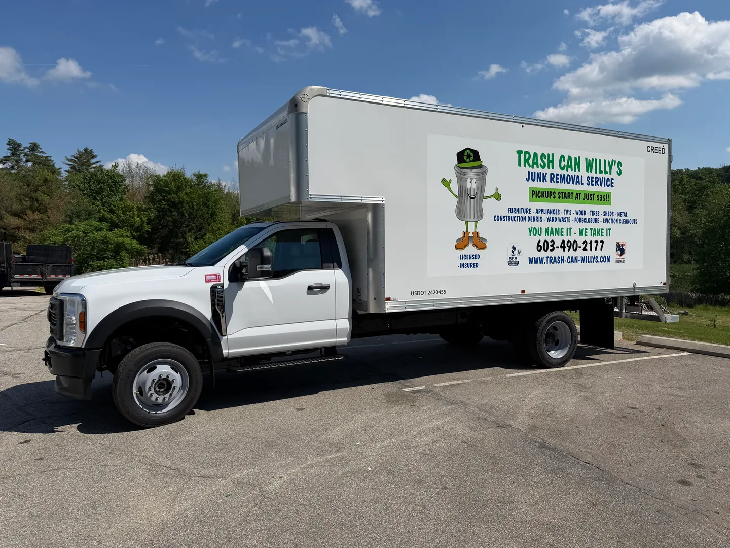 A Trash Can Willy's 20-foot box truck parked on a job